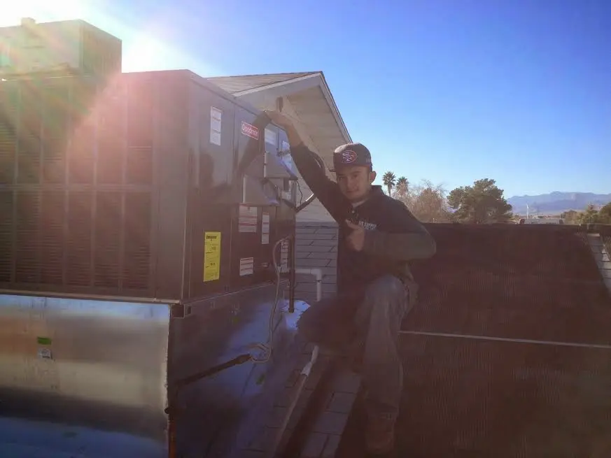 HVAC technician performing HVAC Inspection on a rooftop unit in Loveland